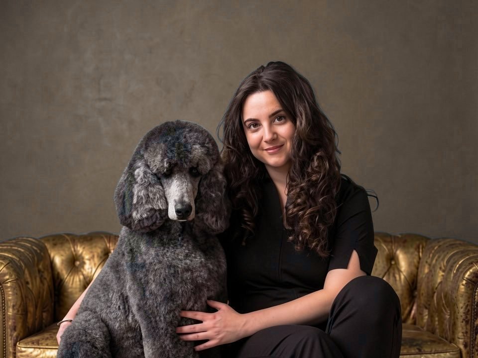 Lucía sentada con el caniche gigante gris, un momento de confianza en la peluquería